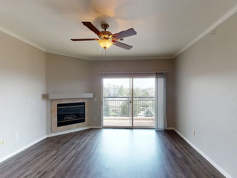 Apartment living room with wood-style flooring, fireplace, and patio or balcony in select homes.