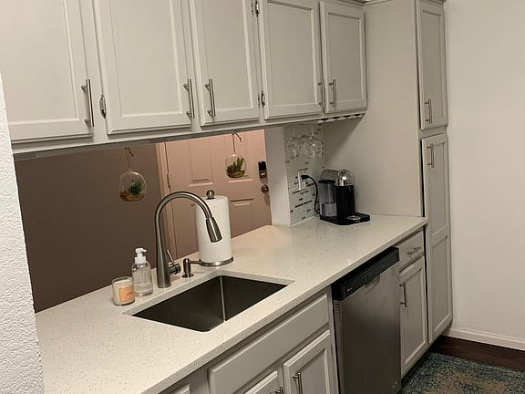 Kitchen with ample storage, quartz countertops and pantry space with pull-out shelving.