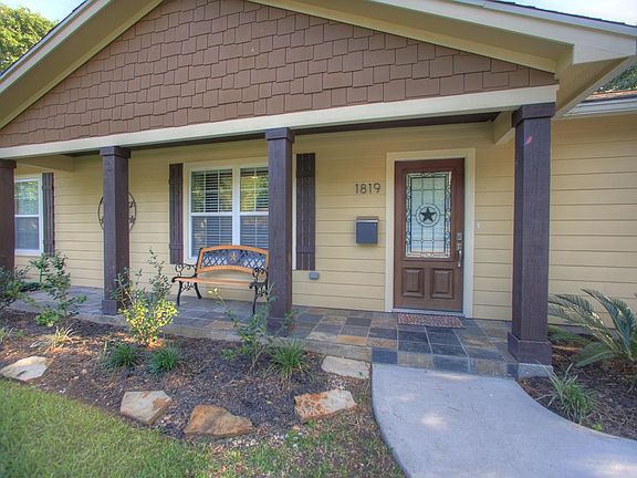 A large front patio provides plenty of space for outdoor seating overlooking the lushly landscaped f