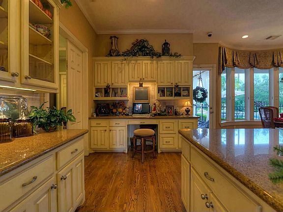  Truly unbelievable gourmet island kitchen - a chef's dream come true! Granite countertops, massive L-shaped island with raised serving bar area, hardwood flooring, antiqued 42" cabinetry, & travertine backsplash!