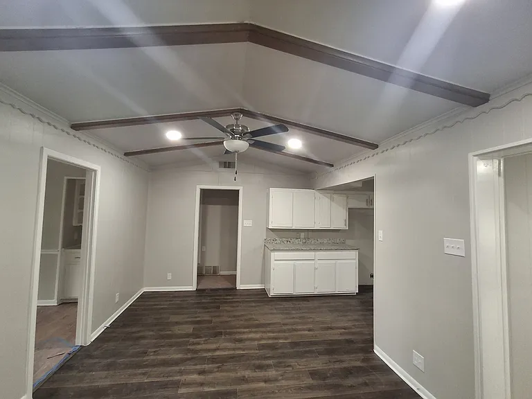View from hallway of dining/breakfast area. New flooring. Kitchen to right (before appliance installation) To left is entrance to front room. Straight ahead is entrance to bedroom hallway.