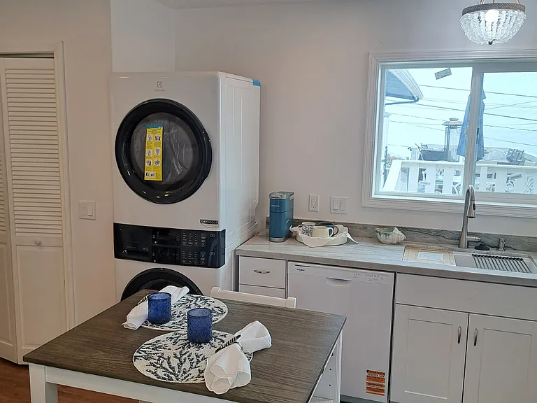 Kitchen, including dishwasher, clothes washer/dryer, kitchen table and food pantry on left, laminate flooring