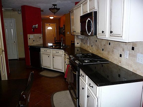 Kitchen with granite counter tops and designer painted cabinets, gas stove