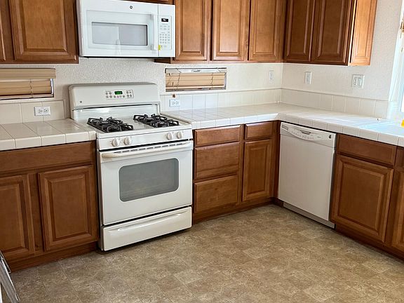 Well lit kitchen with dishwasher, microwave and stove