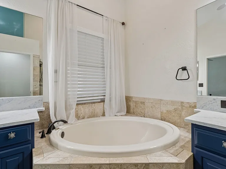 Elegant Primary Bathroom with customed built cabinets, separate toilet room, and lining closest