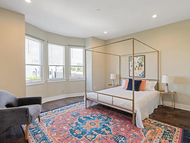 Large primary bedroom w/ window facing front of the home