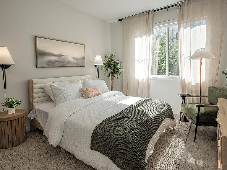 Bright and cozy bedroom with a serene view, featuring a plush bed, stylish decor, and abundant natural light.