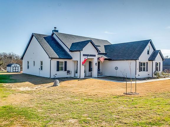Modern inspired farmhouse with a storage shed and a front lawn