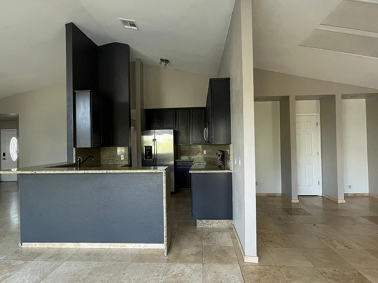 UNFURNISHED. TV room on the right, kitchen on the left.