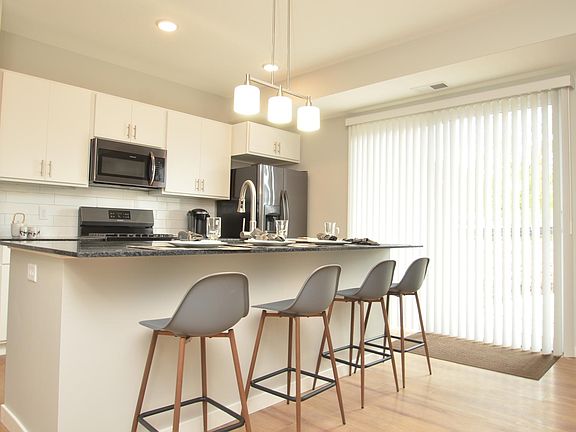 Kitchen has a large granite island and counter stool space for eating