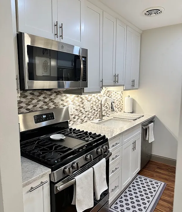 Complete renovated custom soft-close cabinets, white ceramic sink, surrounded by luxurious white quartz.
