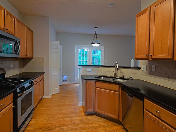 Kitchen with new quartz countertops, refrigerator, gas stove, microwave, garbage disposal, and dishwasher