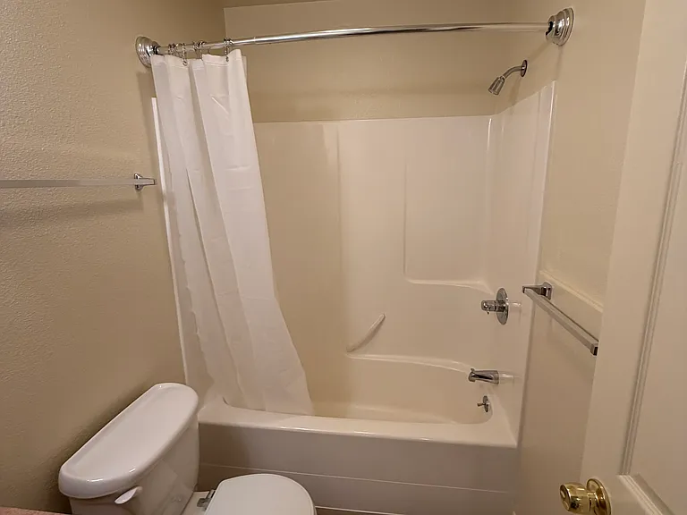 Main bathroom with curved shower curtain rod for more elbow room.