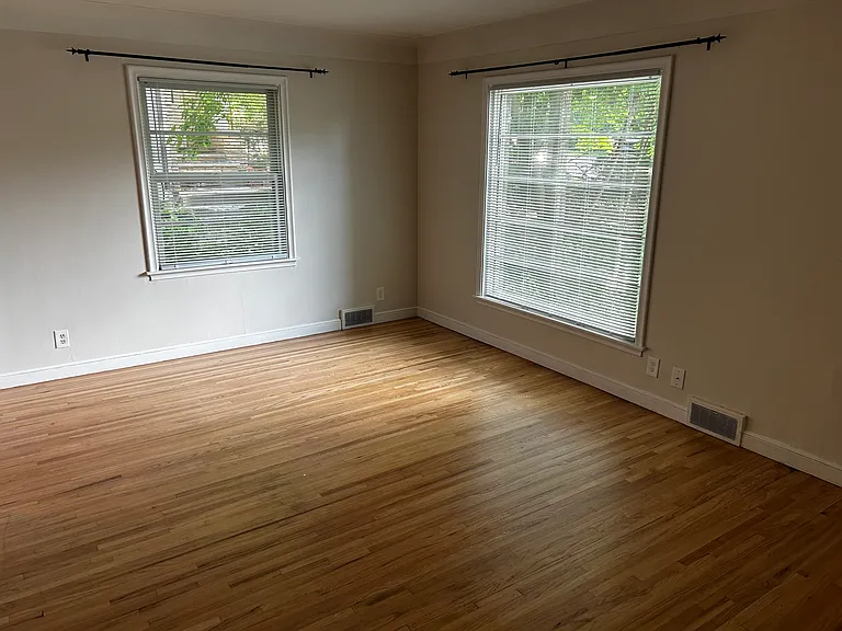 Living room has original wood floors and large East and South facing windows.