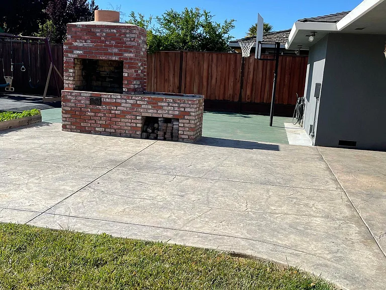 Large wood burning BBQ with basketball court and rubber mat playground. Covered porch for shade extends around the house!