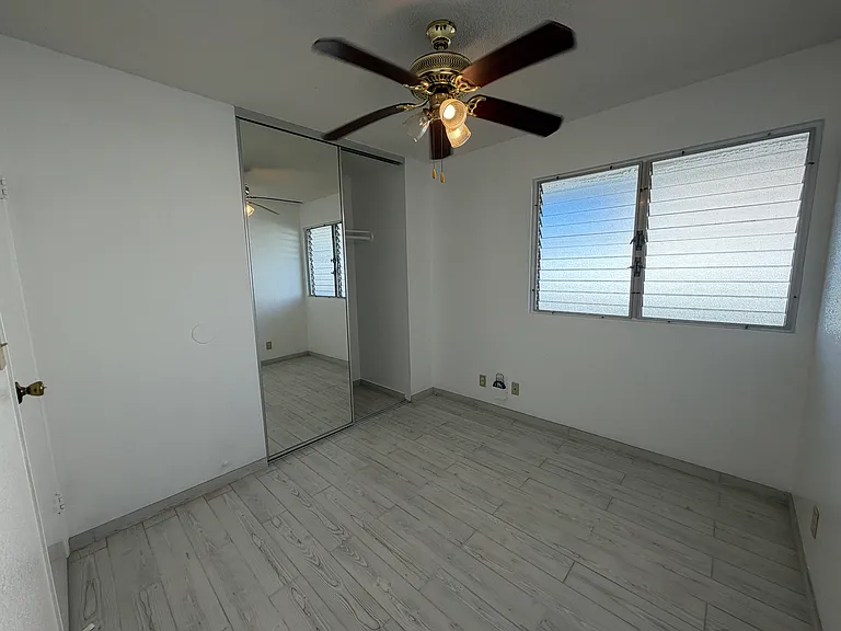Bedroom 3, view 2, floor to ceiling mirrored closet doors, full sized closet.