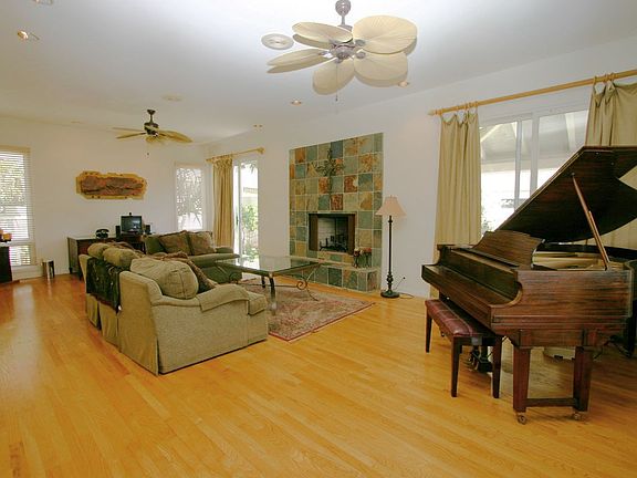 Formal living area with fireplace, warm wood floors and high ceilings