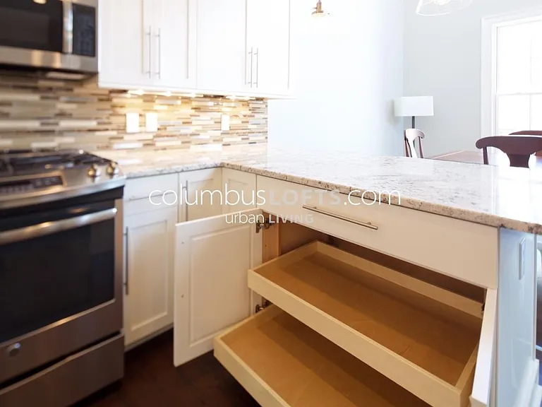 kitchen detail: white granite tops, glass tile backsplash, under-cabinet lighting, high-end appliances