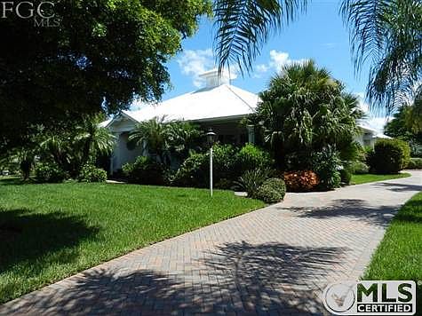 Exterior of home with lush landscaping, freshly sealed pavered driveway, and private corner lot.  Home features easy care vinyl siding and silver metal roof.