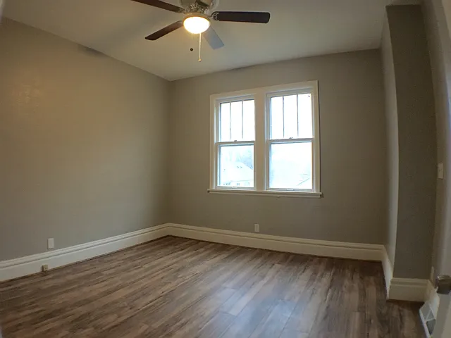 A spacious bedroom on the main floor with ceiling fan.