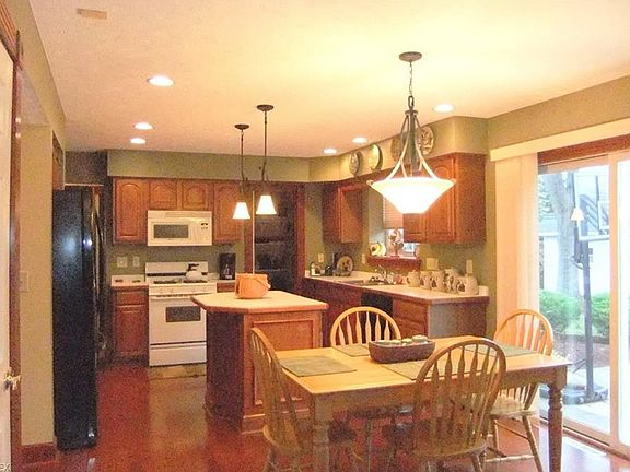 Kitchen with wood flooring and all appliances remain.