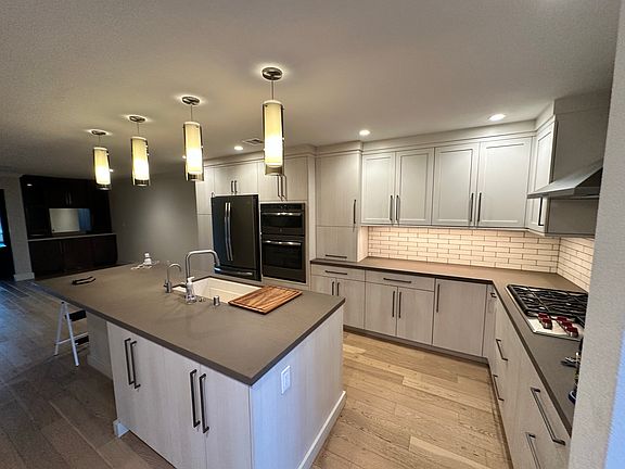 Completely Remodeled Kitchen with Quartz Countertops, Custom Cabinets, GE Profile Appliances, and Hardwood Flooring.