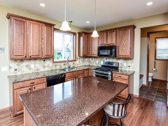 Kitchen features natural woodwork, tile back splash, granite counter tops.