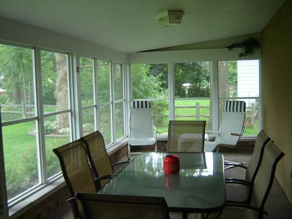 Your wicker furniture will feel right at home in this enclosed screened porch. There is plenty of ro