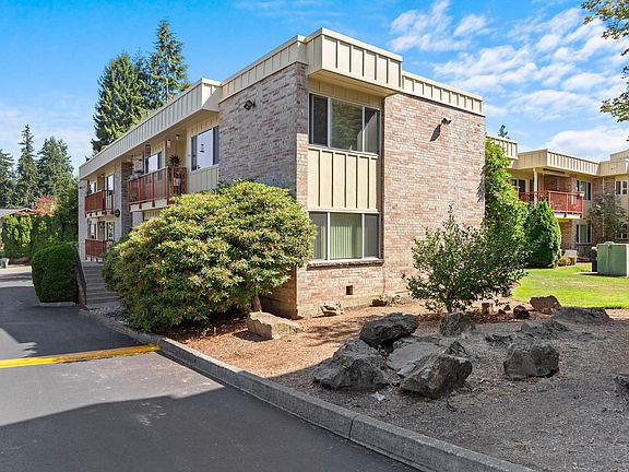 View from parking area to grassy common area immediately outside patio doors.