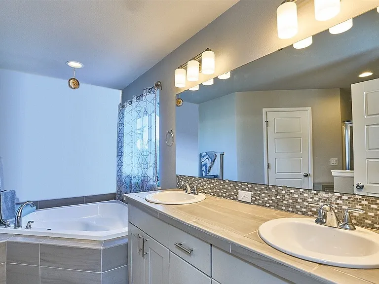 Luxurious five-piece master bath with double sink vanity and a huge walk-in closet.