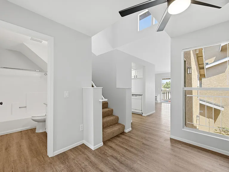 A white room with a staircase and a window.