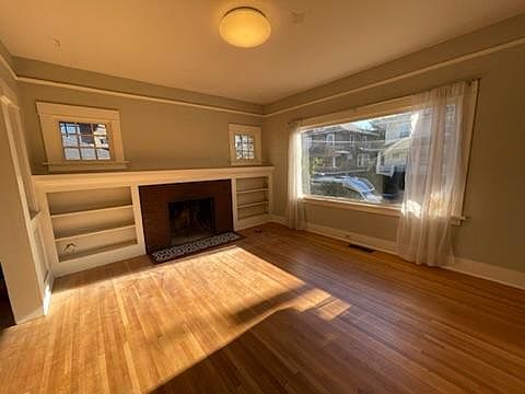 Living room, with a fire burning fireplace and built ins.