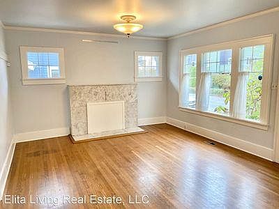 Light-filled upstairs living room with wood floors (throughout entire top floor). Fireplace currently sealed.