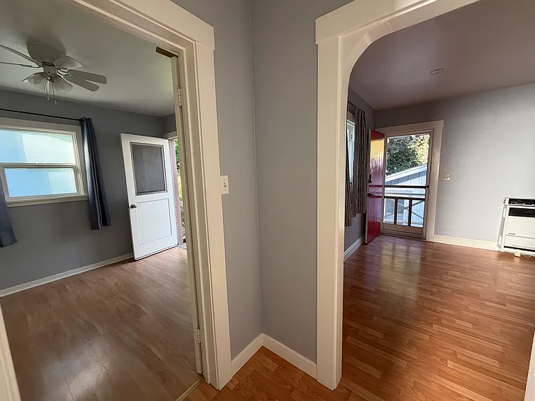 View from the upstairs hallway, looking toward the bedroom patio door/exit (left) and the home's red front door (right).