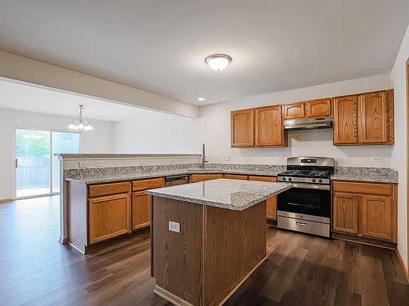 Kitchen is adjacent to Dining Room and includes island with granite overhang for extra eating area, perfect for breakfast.