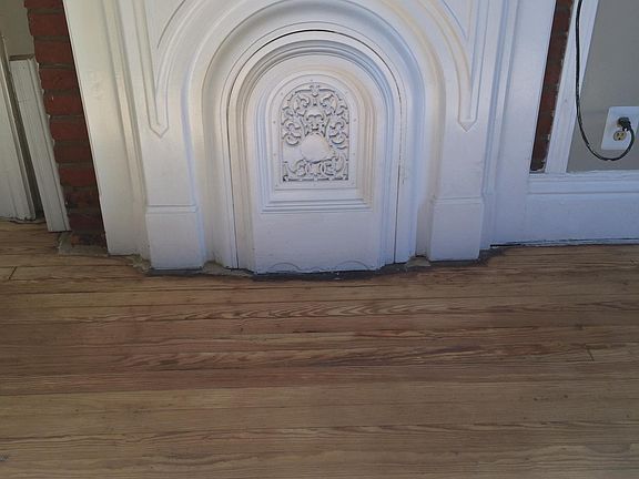 Lighter finished original wood floor and exposed brick fireplace and mantles.