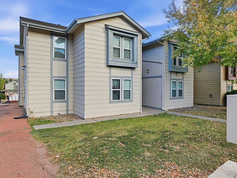 Front of apartment building - parking on left, mailbox in foreground.