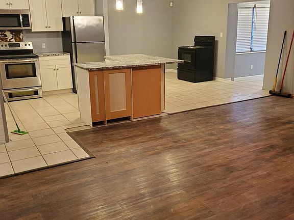 Opposite side of living room looking toward kitchen and dining area. Black oven will be removed.