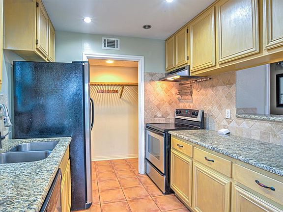 The kitchen has granite countertops and nice appliances. The fridge can remain. The open door is the space for the full size washer/dryer on either side. The washer/dryer are not included.