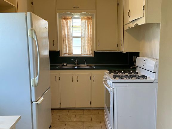 Kitchen with pantry fridge and gas stove provided. Note NO dishwasher.