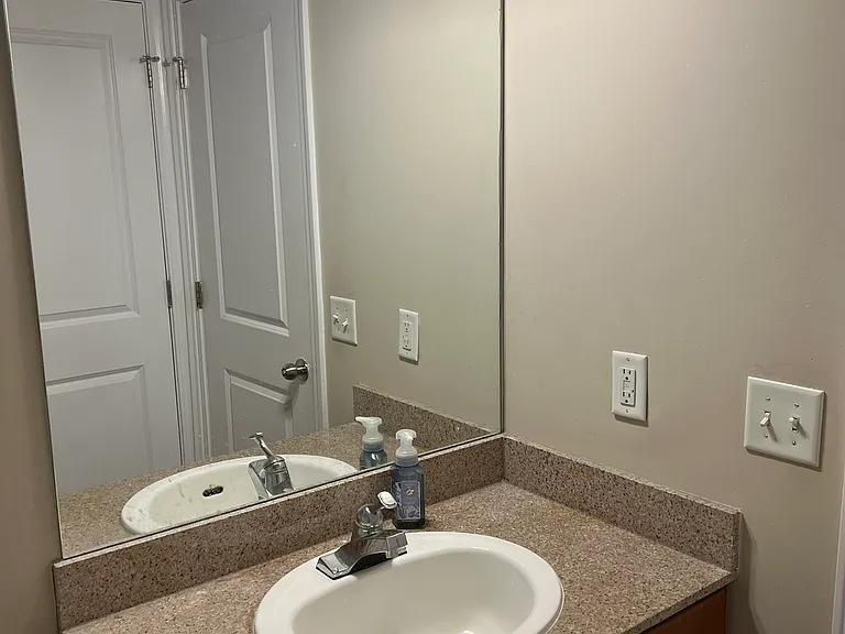 Bathroom sink. Bathroom closet door visible in mirror.