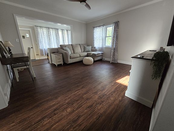 Living room with ceiling fan, 65" Samsung TV, Samsung sound bar w/subwoofer, desk Also, end table w/USB.