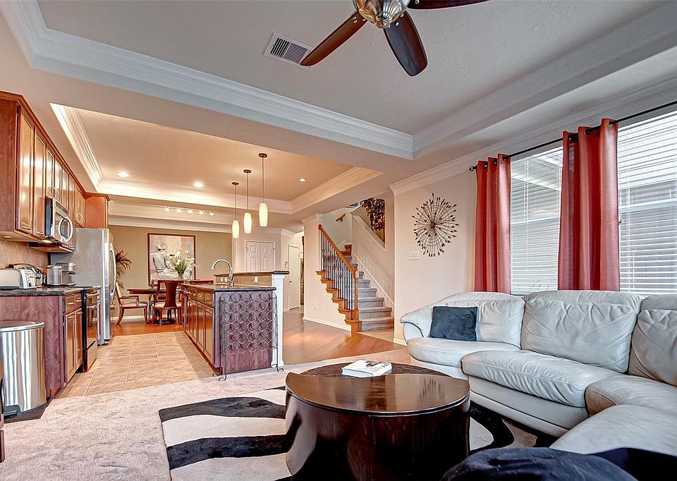 VIEW OF LIVING ROOM TOWARDS KITCHEN, DINING ROOM AND STAIRS LEADING TO 3 BEDROOMS UPSTAIRS