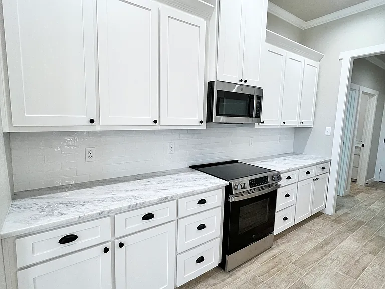 Custom, cabinetry, marble countertops, and stainless steel appliances