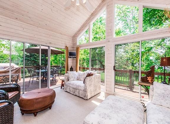 Vaulted sun room overlooks the beautiful backyard with a wall of windows that brings the outside in.