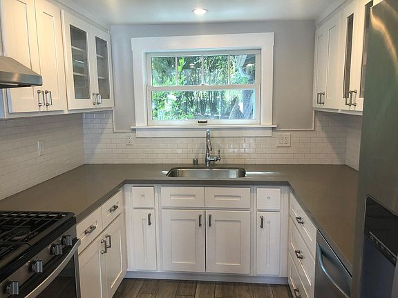 Chef kitchen with stainless steel appliance, gas range and quartz countertops