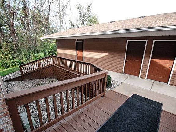 This view is from the front entry door of the building and highlights the ranch style garage with back doors leading to the walkway. The garage features an automatic door opener, concrete floor and extra built in storage shelving.