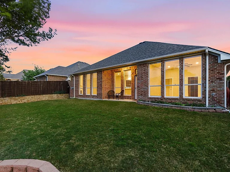 Brick exterior with a dark shingle roof and white trim