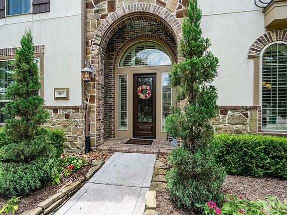 Charming stacked stone flowerbeds leads up to an brick & stone arched front porch welcoming you into this inviting home!