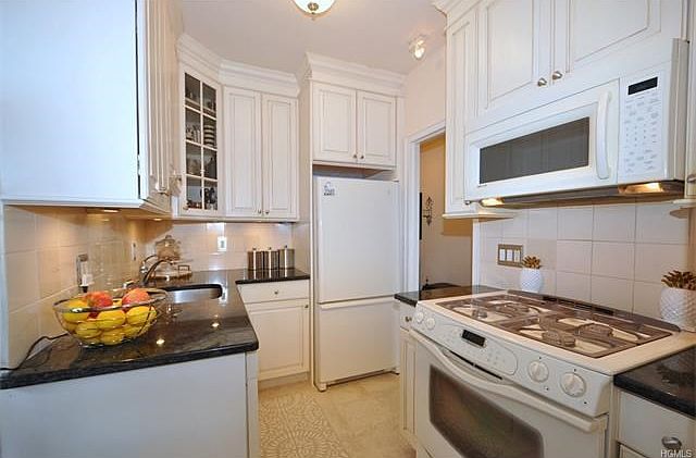 Renovated Kitchen has Granite counters, custom cabinets, dishwasher, microwave, refrigerator, slide 